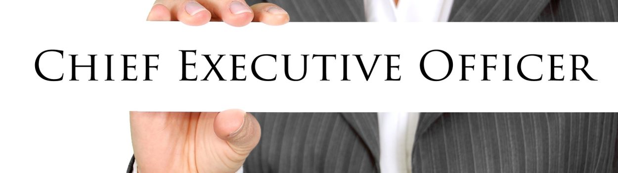 woman holding a block that says 'chief executive officer'