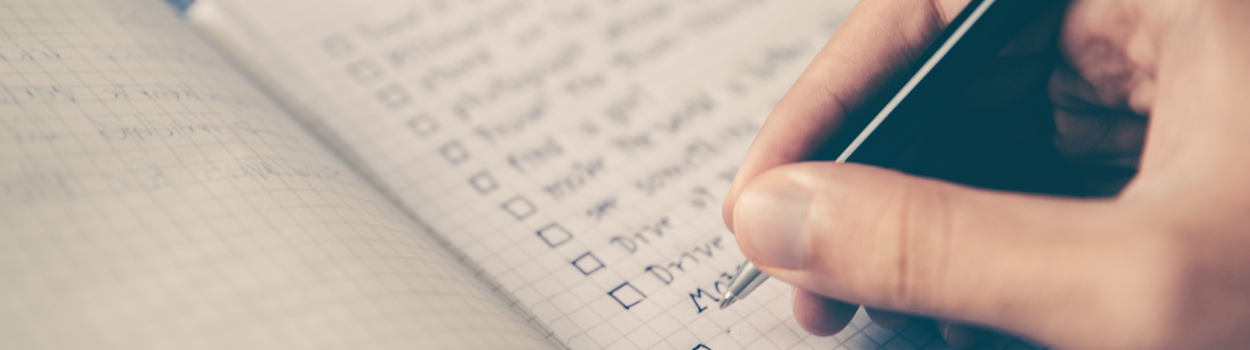 hand writing on a checklist with a pen