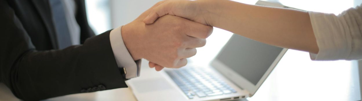How to Handle Low Offer hands shaking cross desk with computer in desk in background