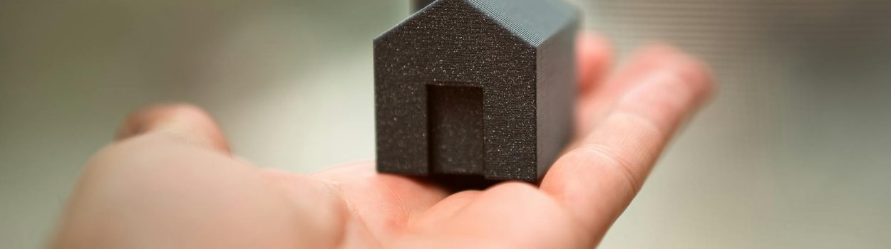 pexels-jakubzerdzicki-29091316 Hand Holding Small Model House Symbolizing Real Estate