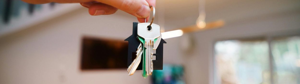 pexels-jakubzerdzicki-29871187 Hand holding up a set of house keys