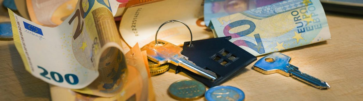 pexels-jakubzerdzicki-30139520 dollar bills and coins and calculator around a house key/keychain