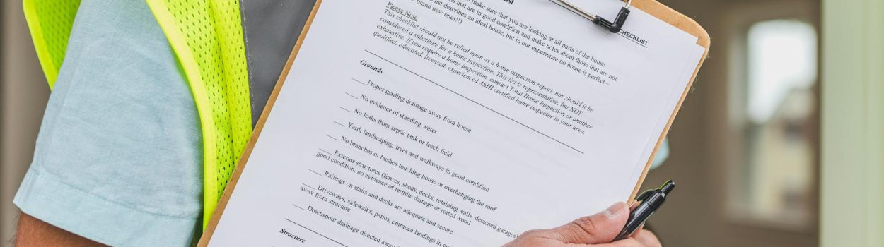 close up of home inspection checklist on clipboard held by home inspector